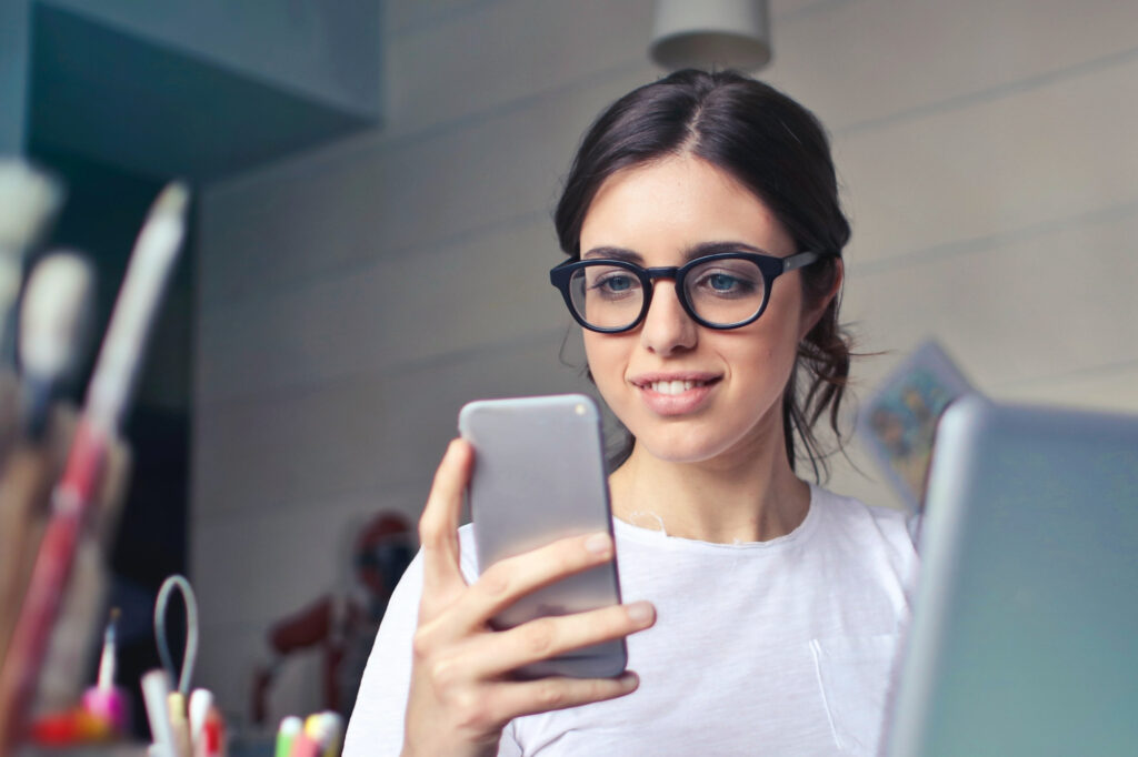 young woman looking at phone in a work environment